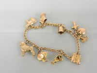 Lot 172 - A gold charm bracelet with eight 9ct gold charms