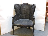 Lot 563 - A French ebonised bergère chair