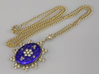 Lot 79 - A blue guilloché enamel and split pearl gold pendant
