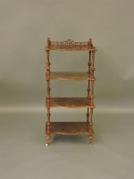 Lot 747 - A Victorian walnut four tier serpentine front whatnot