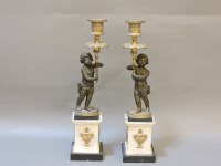 Lot 350 - A pair of bronze candlesticks in the form of putti holding torches