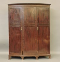 Lot 543 - An Edwardian bow front triple door wardrobe