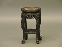 Lot 435 - A small Chinese carved hardwood urn stand