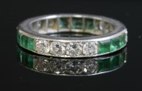 Lot 422 - An emerald and diamond full eternity ring