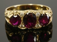 Lot 372 - A three stone ruby and diamond carved head ring