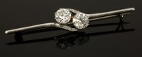 Lot 412 - An Art Deco two stone diamond crossover brooch with diamond set shoulders