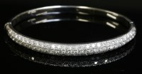 Lot 563 - A white gold diamond set hinged bangle