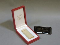 Lot 76 - A Cartier oval ivory coloured lacquer lighter