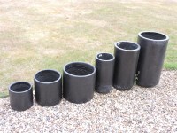 Lot 556 - A set of six graduated composite cylindrical planters