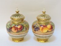 Lot 157 - A matched pair of Royal Worcester pot pourri vases and pierced covers