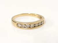 Lot 26 - An 18ct gold seven stone diamond channel set half eternity ring