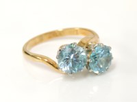 Lot 7 - A gold two stone blue zircon crossover ring