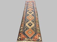 Lot 395 - A long blue and red ground Persian runner