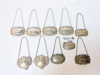 Lot 76 - A near set of four silver decanter labels