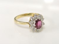 Lot 214 - A 18ct gold oval cut ruby and diamond cluster ring