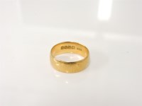 Lot 216 - An 18ct gold d-shaped wedding ring