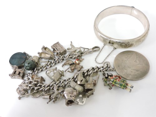 Lot 1061 - A silver curb bracelet with various silver charms