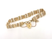 Lot 1030 - A 9ct gold four row twisted gate link bracelet with padlock