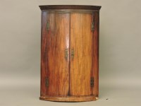 Lot 739 - A George III mahogany bow front corner cupboard