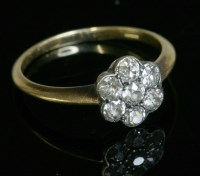 Lot 445 - A diamond set daisy cluster ring