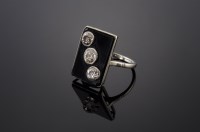 Lot 451 - An Art Deco three-stone diamond and onyx plaque ring