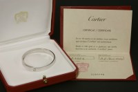 Lot 559 - A white gold Cartier anniversary hinged bangle