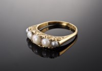 Lot 415 - An 18ct gold Edwardian split pearl and diamond carved head ring