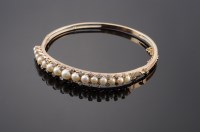 Lot 411 - A late Victorian pearl and diamond hinged bangle