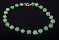 Lot 453 - A uniform jade bead bracelet