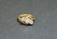Lot 24 - An 18ct gold three stone diamond crossover ring