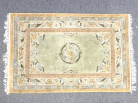 Lot 394 - A Chinese green ground silk rug