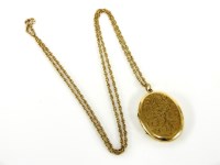 Lot 20 - A 9ct gold oval locket engraved with scrolling design