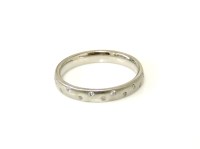 Lot 3 - A court shaped platinum wedding ring with scattered diamonds.
4.51g