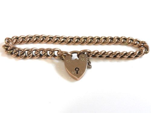 Lot 60 - A gold hollow curb link bracelet with padlock