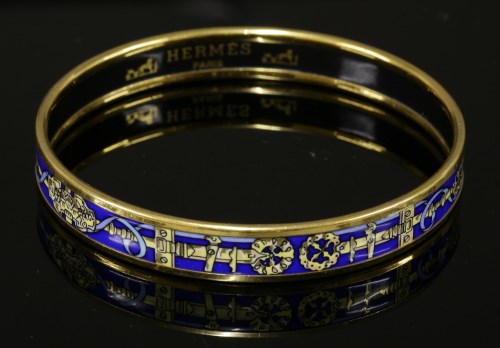 Lot 1004 - An Hermès narrow blue enamel gold-plated bangle