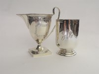 Lot 155 - A hallmarked silver cream jug with engraved detail and a silver christening mug (2)