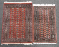 Lot 507 - Two eastern rugs decorated with geometric designs on a red ground