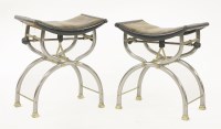 Lot 594 - A pair of polished steel and brass X-framed adjustable music stools