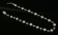 Lot 79 - An Art Deco platinum and pearl bracelet with series of faceted platinum beads
