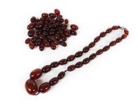 Lot 1098 - A collection of graduated olive shaped cherry coloured Bakelite beads