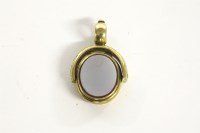 Lot 1000 - A rolled gold oval hardstone swivel hinged locket/seal