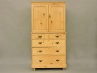 Lot 412 - A stripped pine cupboard with two panelled doors