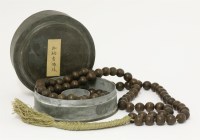 Lot 346 - A string of wooden beads ending with a tassel