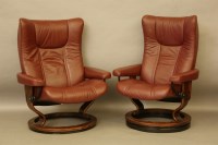 Lot 414 - A pair of modern leather upholstered revolving and reclining arm chairs