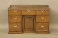 Lot 497 - A 20th century oak kneehole desk