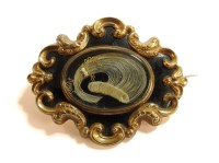 Lot 49 - A gold cased black enamel memorial brooch