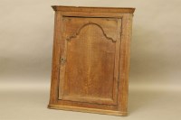 Lot 585 - A George III oak corner cabinet