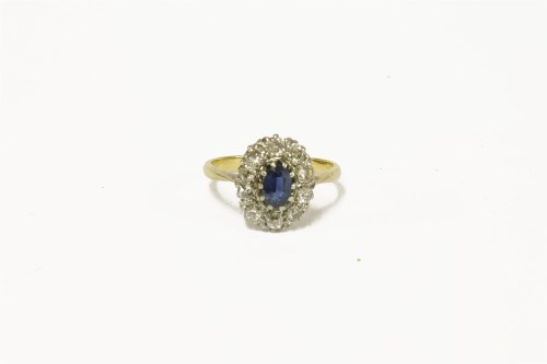 Lot 53 - A gold sapphire and diamond cluster ring with central oval mixed cut sapphire