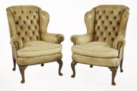 Lot 554 - A pair of yellow leather wing armchairs