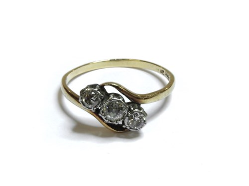 Lot 66 - A gold three stone diamond crossover ring
